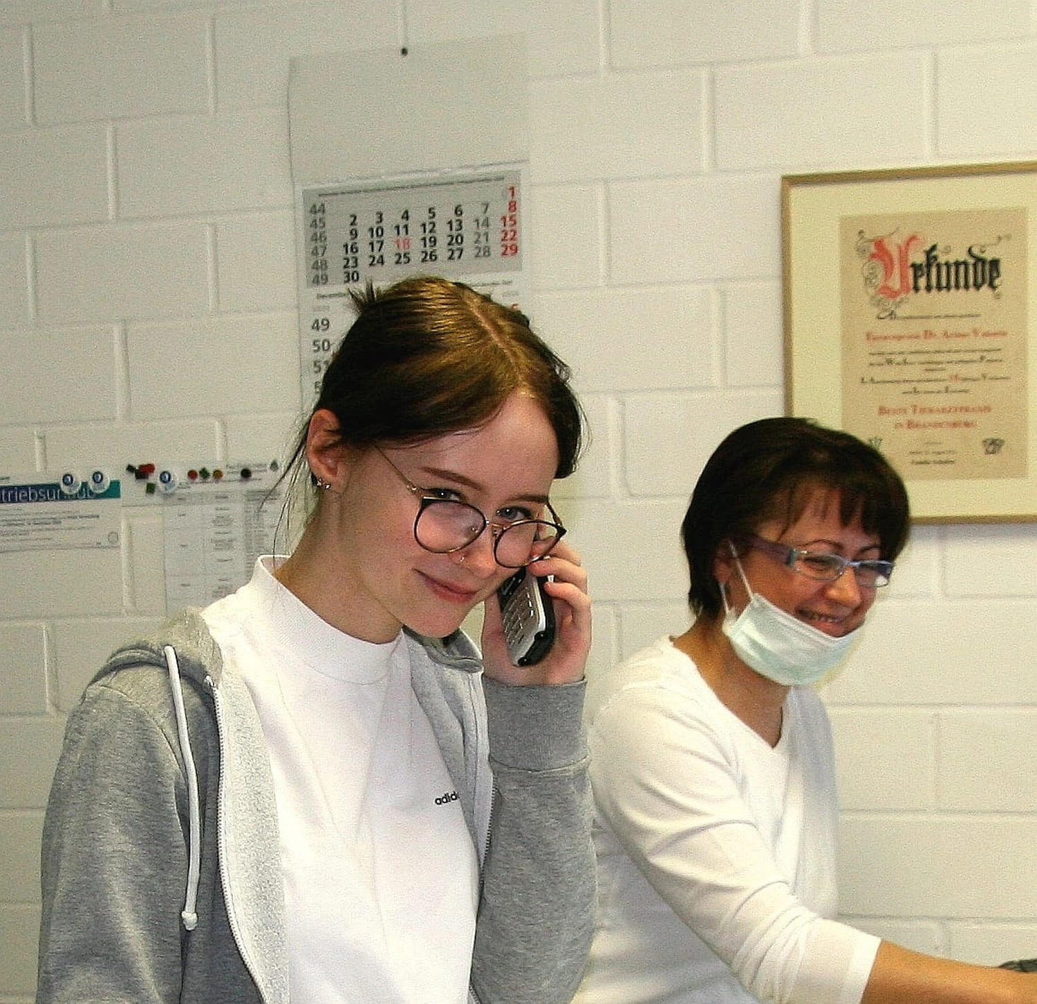 Krankenhauspersonal und eine junge Frau am Telefon